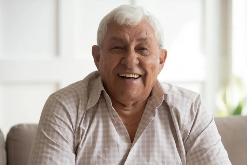 Paciente mayor sonriendo tras su tratamiento de implantes